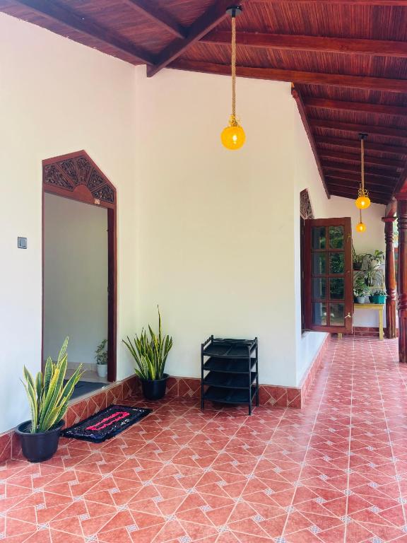 a patio with potted plants and a mirror on the wall at Villa Dinusara in Weligama