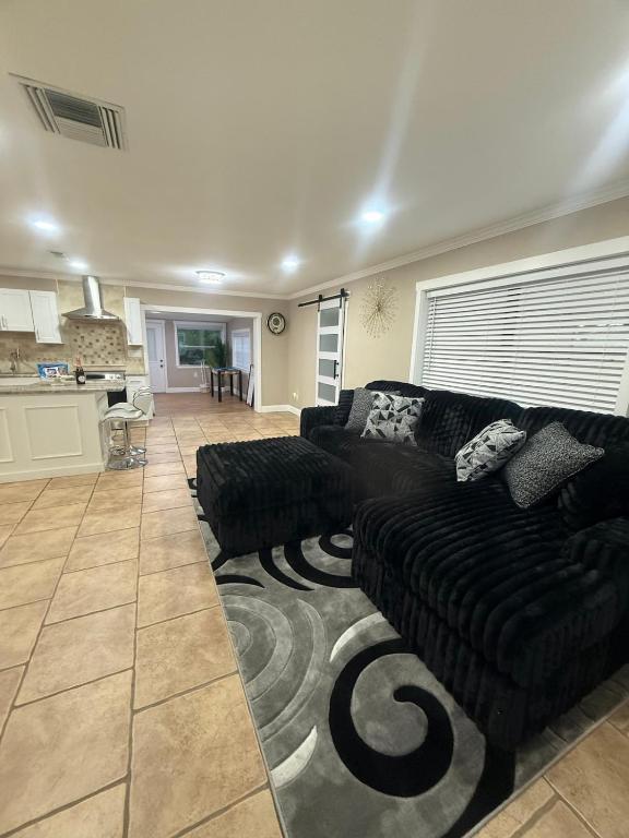 a living room with black couches and a kitchen at Njade & Luxury Stay in Spring Hill