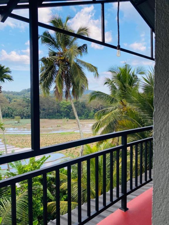 a view from the balcony of a resort with palm trees at Sawmya Guest House in Randeniya