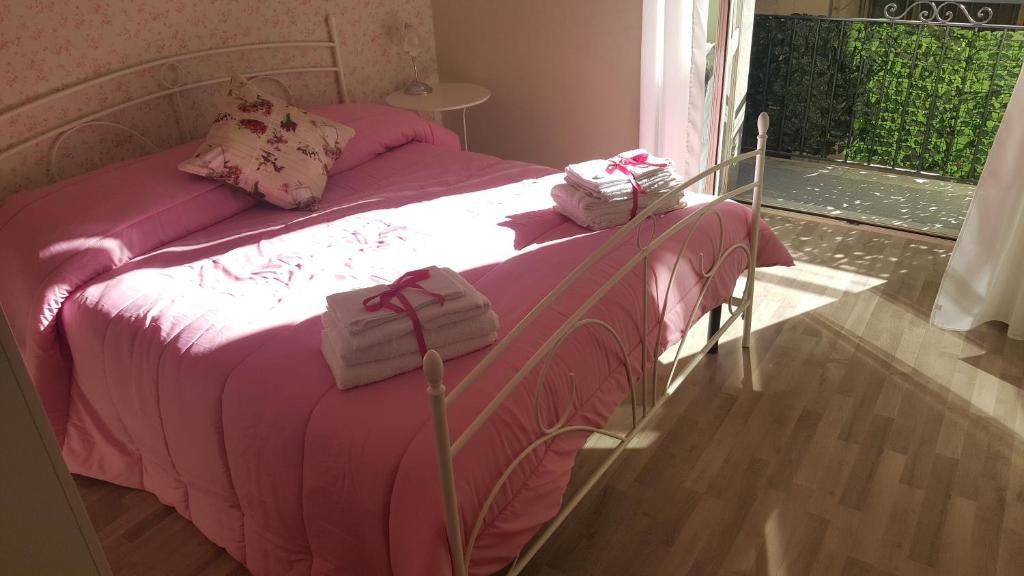 ナポリにあるVacanze Napoletaneのベッド(ピンクのシーツ、タオル付)