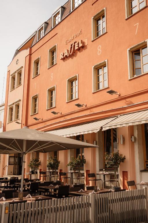 a building with tables and chairs in front of it at Hotel Raffel in Jennersdorf