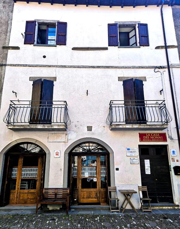 a white building with two doors and two balconies at La Casa dei Nonni in Berceto