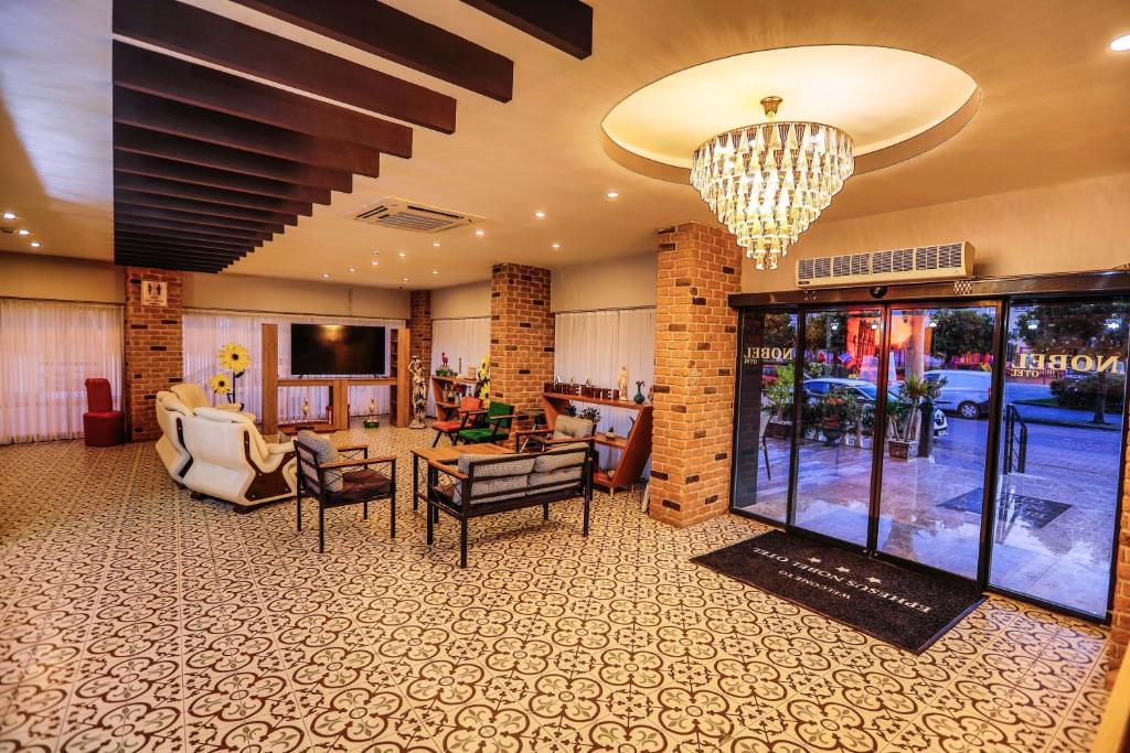 a lobby with a living room with a chandelier at Ephesus Nobel Otel in Selçuk