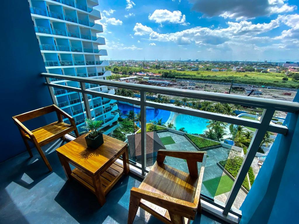 a balcony with a table and chairs and a view at Azure North Monaco 10F Pool View with Netflix and WiFi and Karaoke in San Fernando