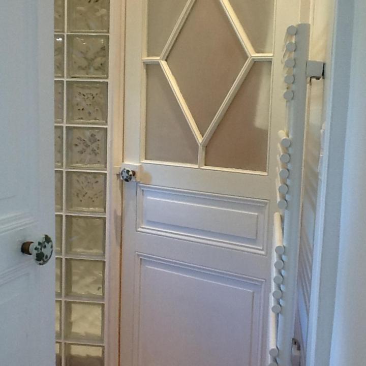 une porte blanche avec des panneaux de verre dans une pièce dans l'établissement Château de Saint-Agoulin, à Saint-Agoulin