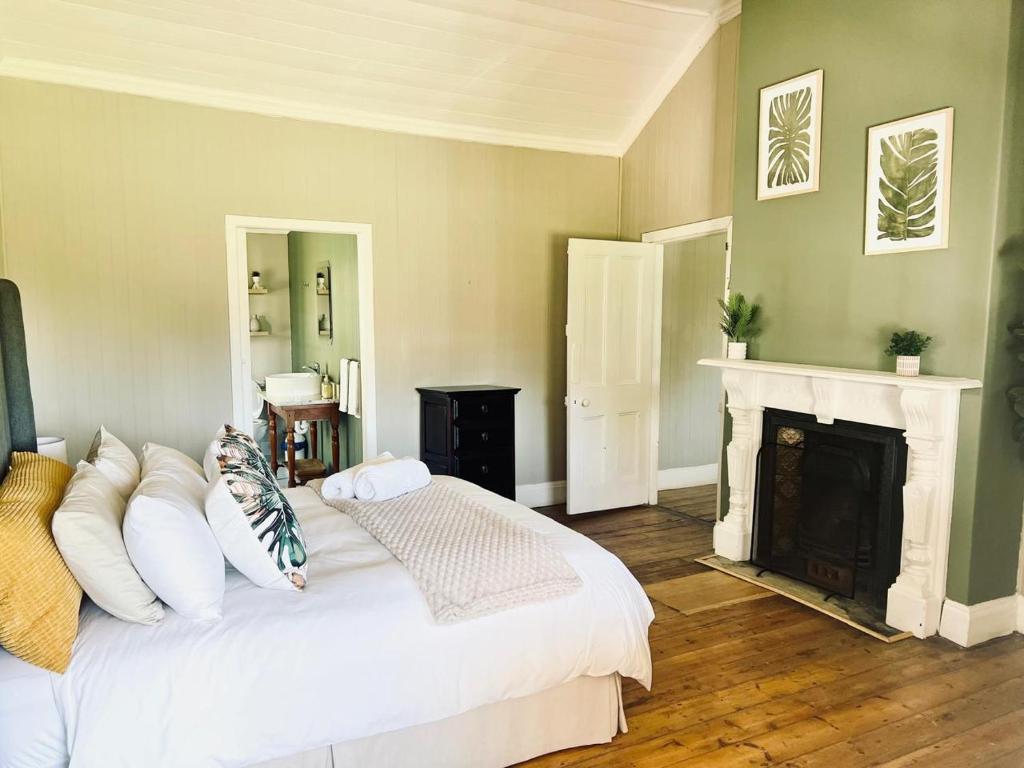 a bedroom with a white bed and a fireplace at Briar & Bloom 1 in Hilton