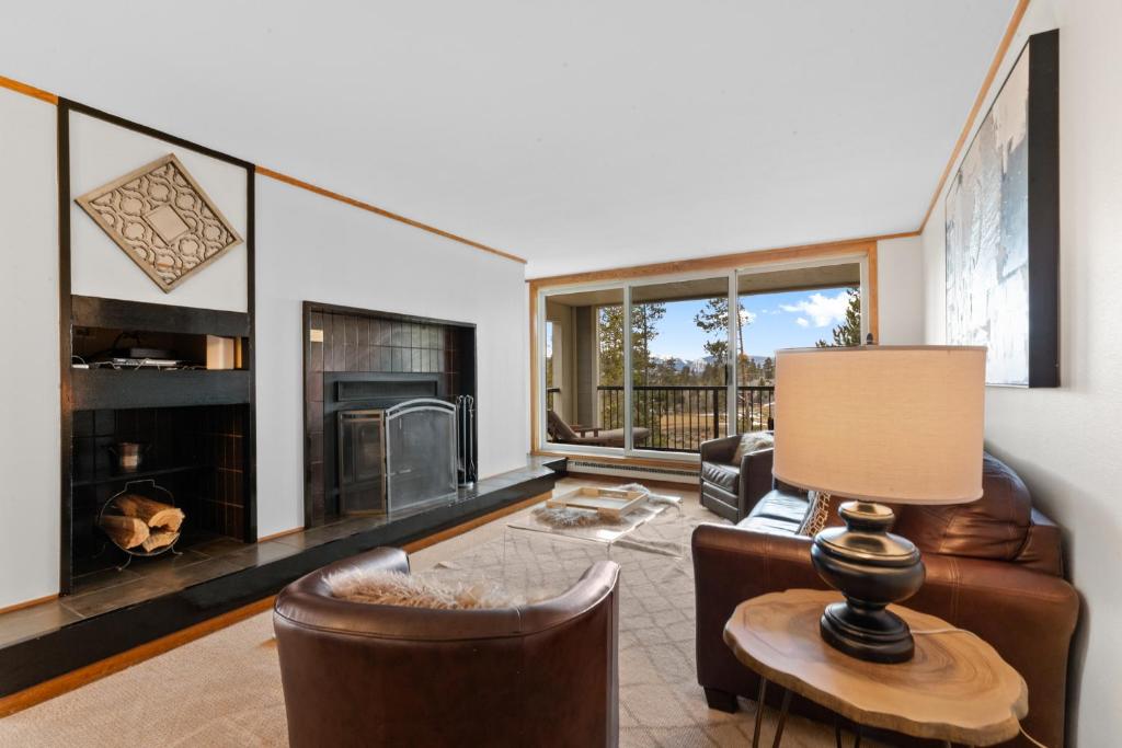a living room with a fireplace and leather furniture at Pines #2124 in Keystone
