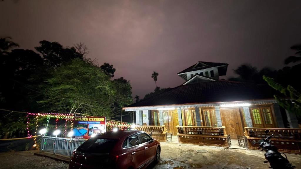 a house with a car parked in front of it at night at Golden cypress resort with pool in Vythiri