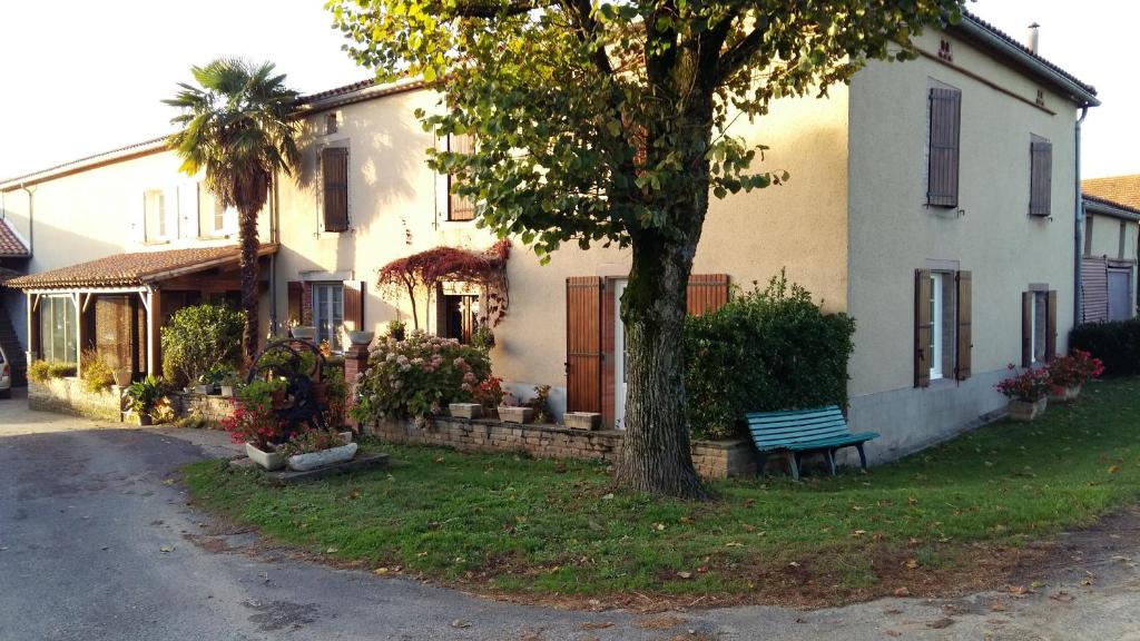 a house with a tree and a bench in front of it at Charmante maison à la ferme in Valderiès