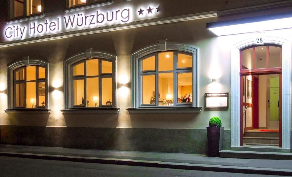un edificio de hotel con ventanas y un cartel en él en City Hotel Würzburg, en Würzburg