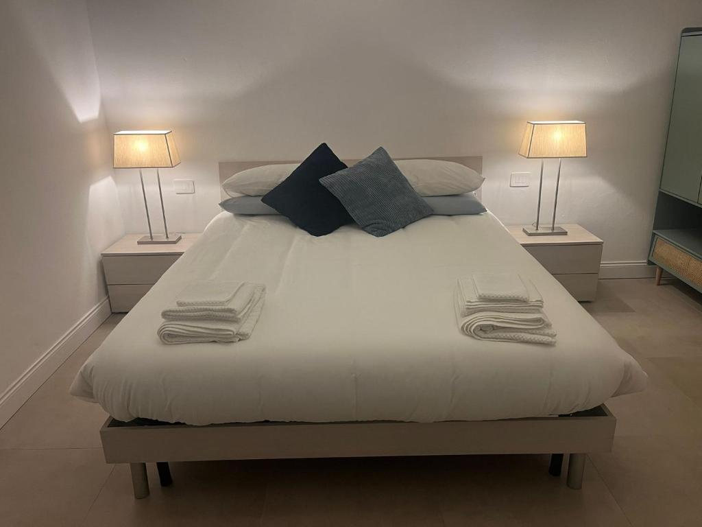 a bedroom with a large white bed with two lamps at El Nido Suite in Tornavento