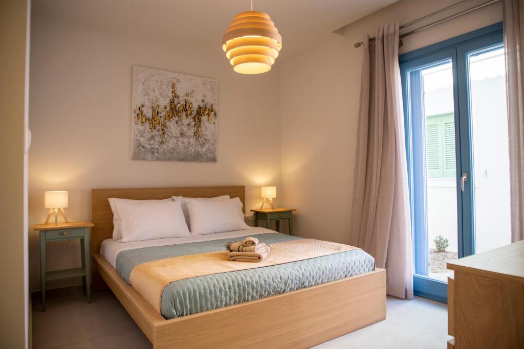 a bedroom with a bed with two lamps and a window at Casa Mary Aegina in Egina