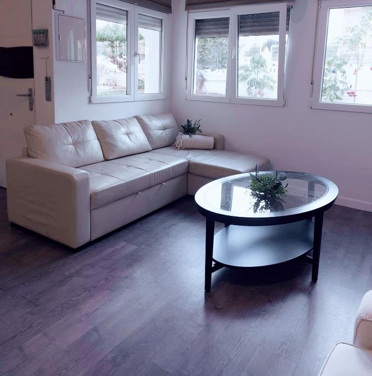 a living room with a white couch and a table at Bonito bungalow en la playa in Gran Alacant