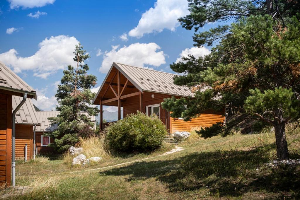 a log cabin with trees in front of it at Huttopia Val Cenis in Val Cenis