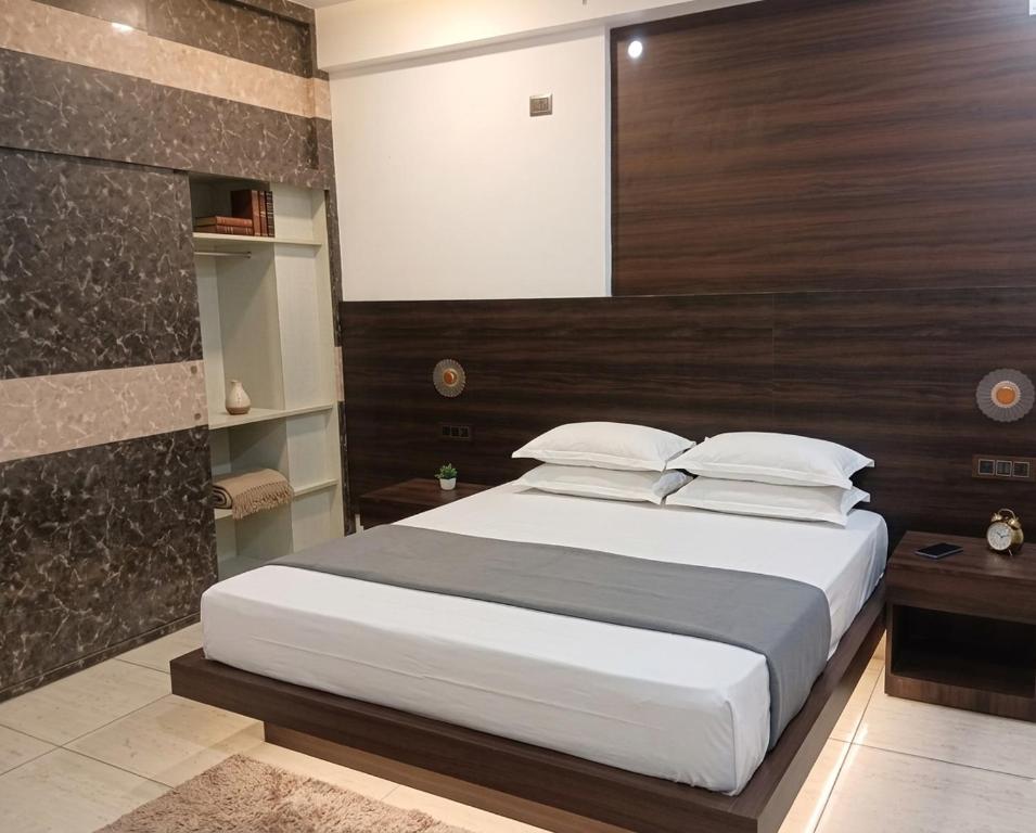 a bedroom with a large bed with a wooden headboard at Hotel Vivara in Lucknow