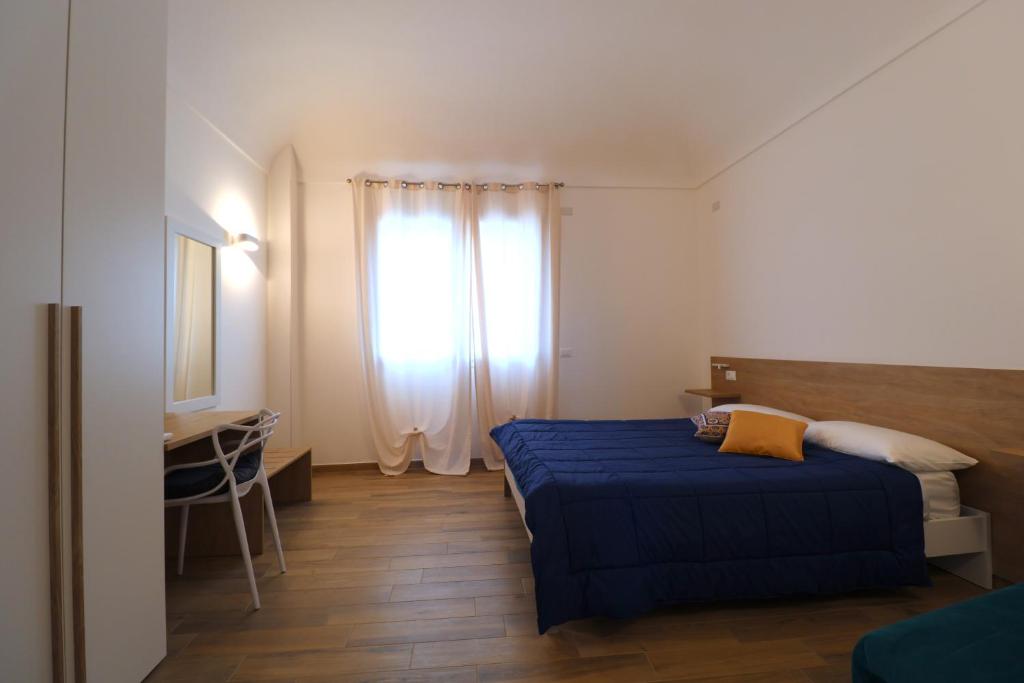 a bedroom with a blue bed and a window at Mastru Cicciu in Custonaci