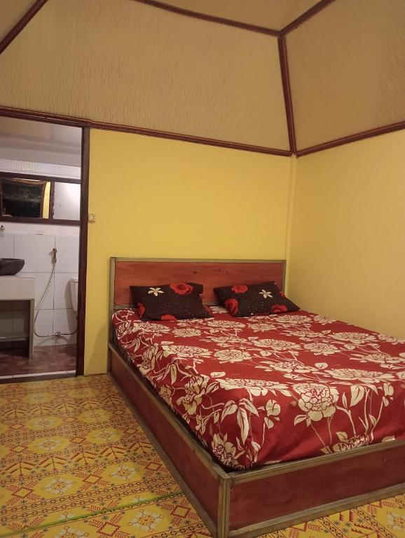 a bedroom with a bed with a canopy at Pondok sunset inn in Senaru