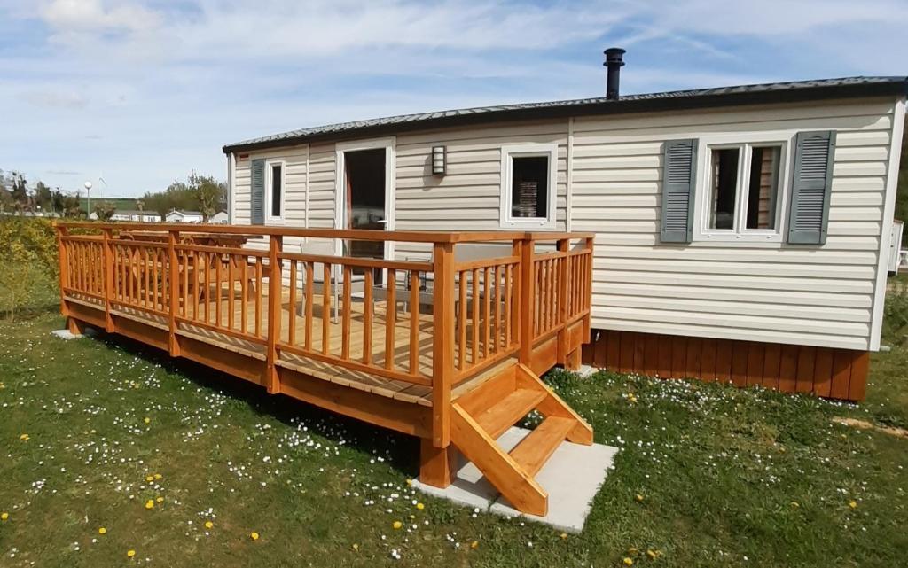 a mobile home with a large wooden deck at Le doux refuge de l'Yères in Touffreville-sur-Eu