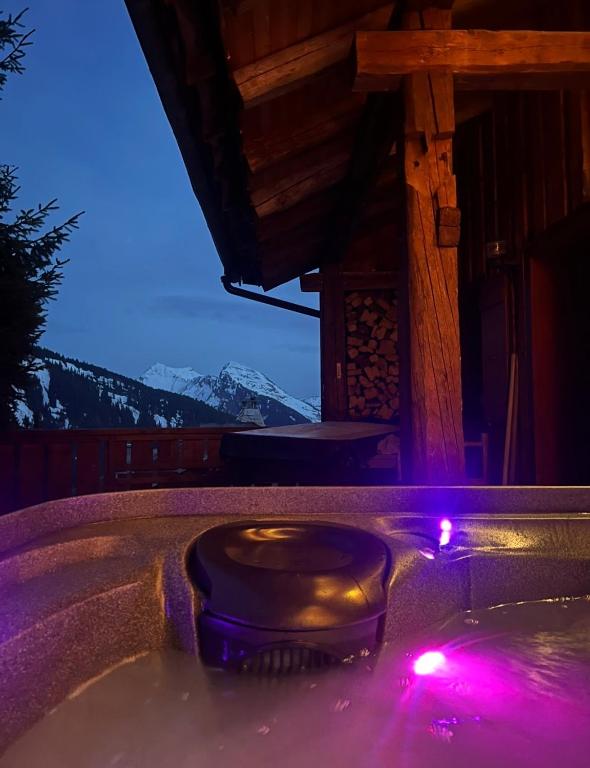 a bath tub with a toilet in it with purple lights at Chalet de ZORE in Morzine