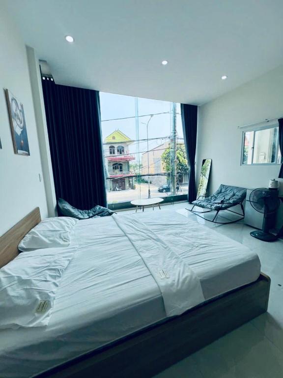 a large bed in a room with a large window at Tie Homestay in Dong Hoi