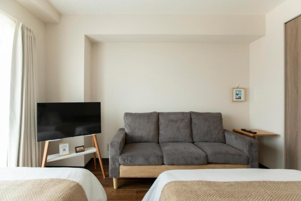 a living room with a couch and a tv at Planetarium N in Yamashitachō