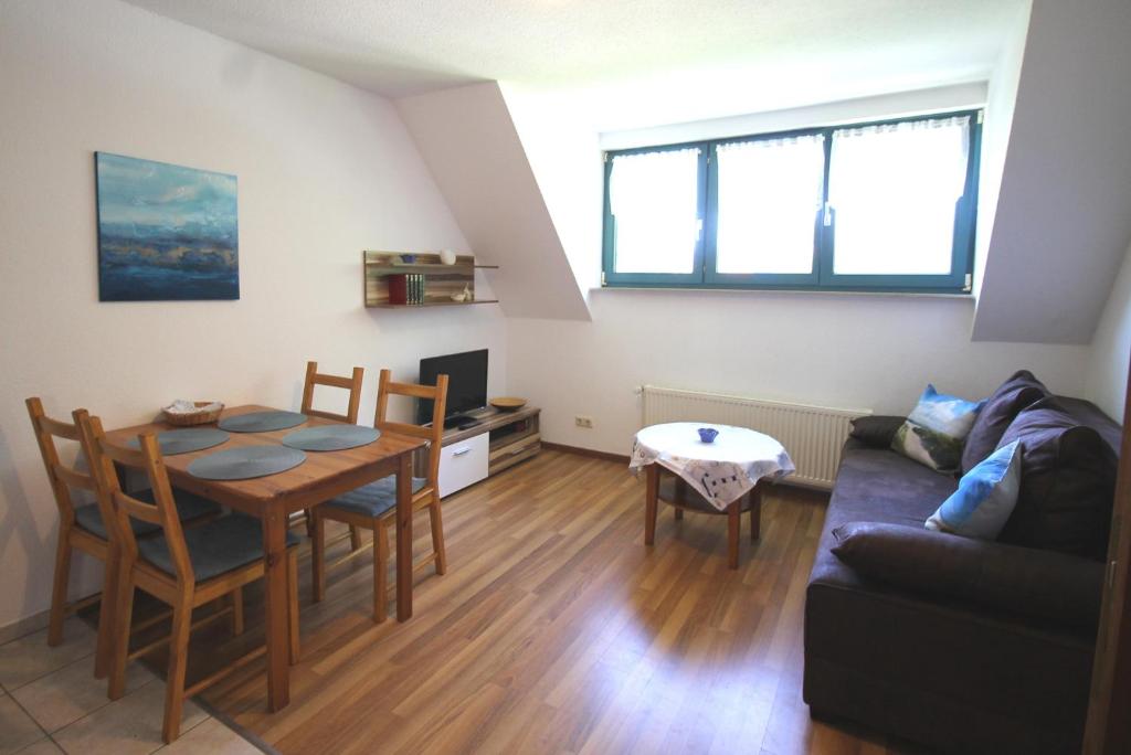 a living room with a table and a couch at Deichkoje 06 in Prerow
