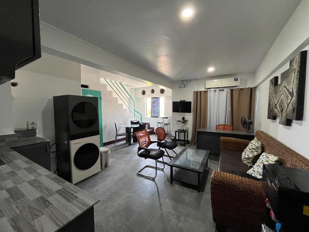 a living room with a couch and a tv at Wanderers Backpacker Condotel in Pusok