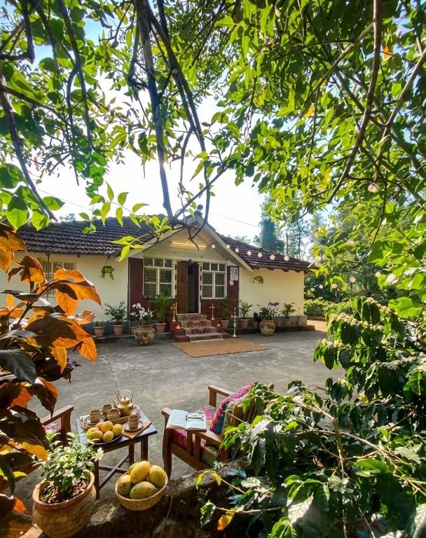 a house with a table and chairs in a yard at Gopetown Homestay in Mudigere