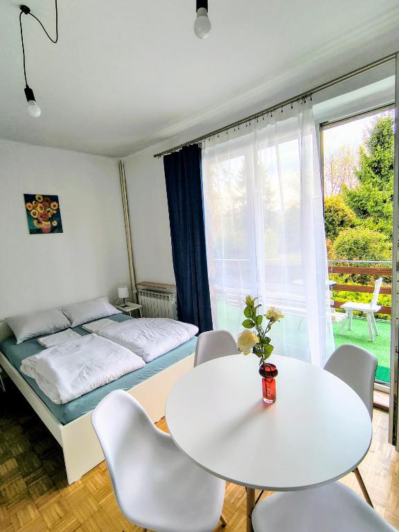 a bedroom with a bed and a table and chairs at Luna Rooms Oświęcim in Oświęcim