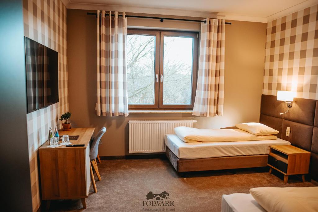 a hotel room with two beds and a window at Hotel Folwark in Zgierz