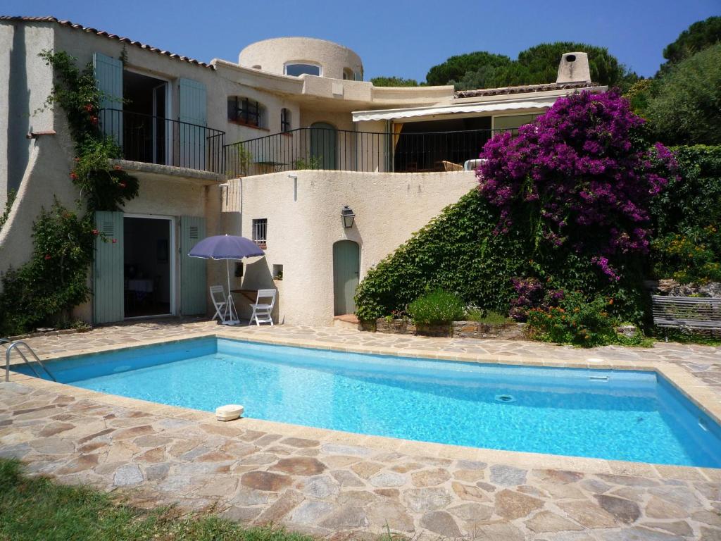 a villa with a swimming pool in front of a house at Meublé La Sergerie in Le Lavandou