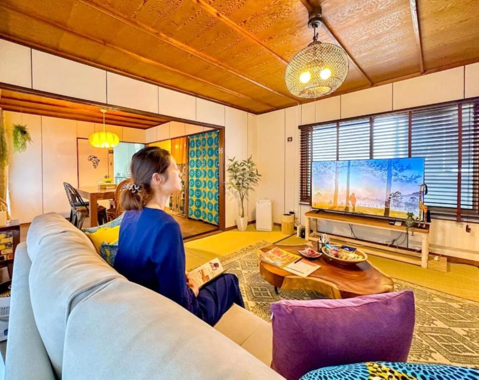 a woman sitting on a couch in a living room at PolePole in Takamatsu