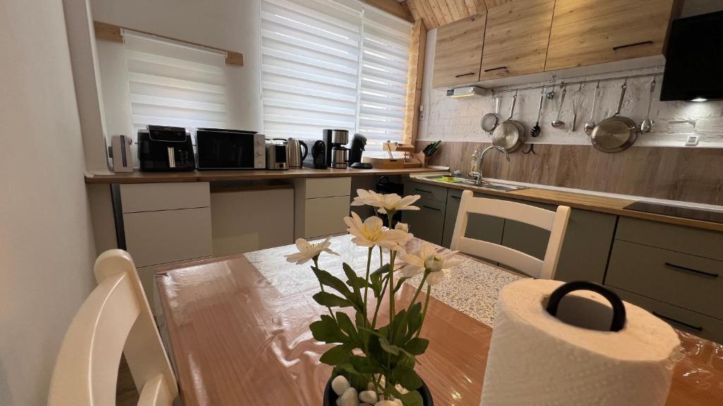 a kitchen with a table with a vase of flowers on it at A2 - Viel Platz für alle in Wernigerode