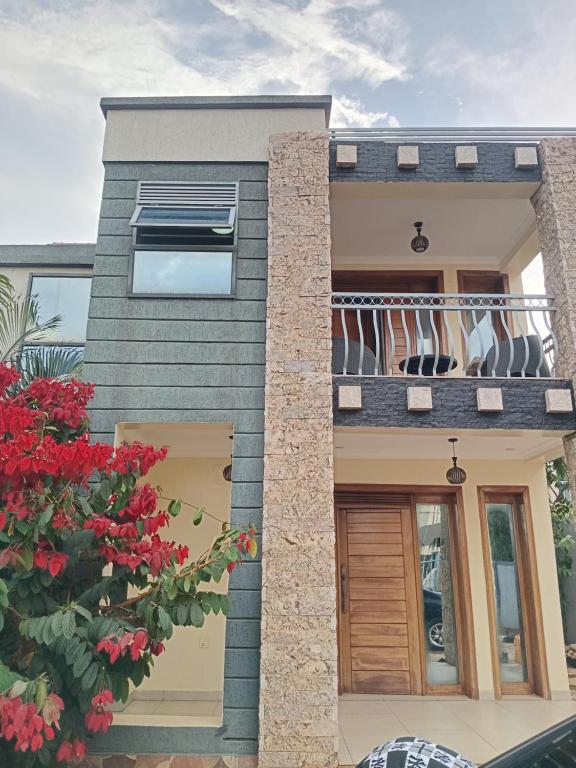 a house with a balcony with red flowers at Relaxing Lodge in Kigali