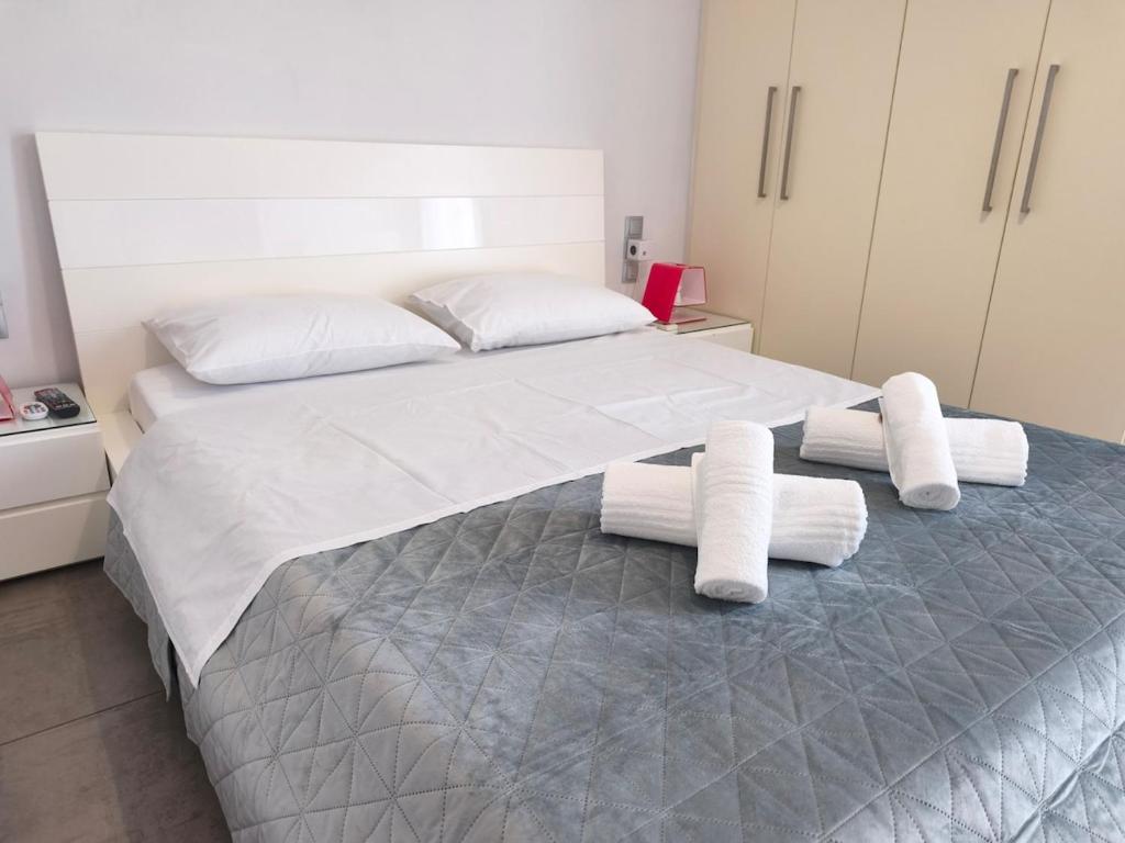 a bedroom with a large bed with towels on it at DENNIS PATRASSO - Modern apartment in Patras in Patra