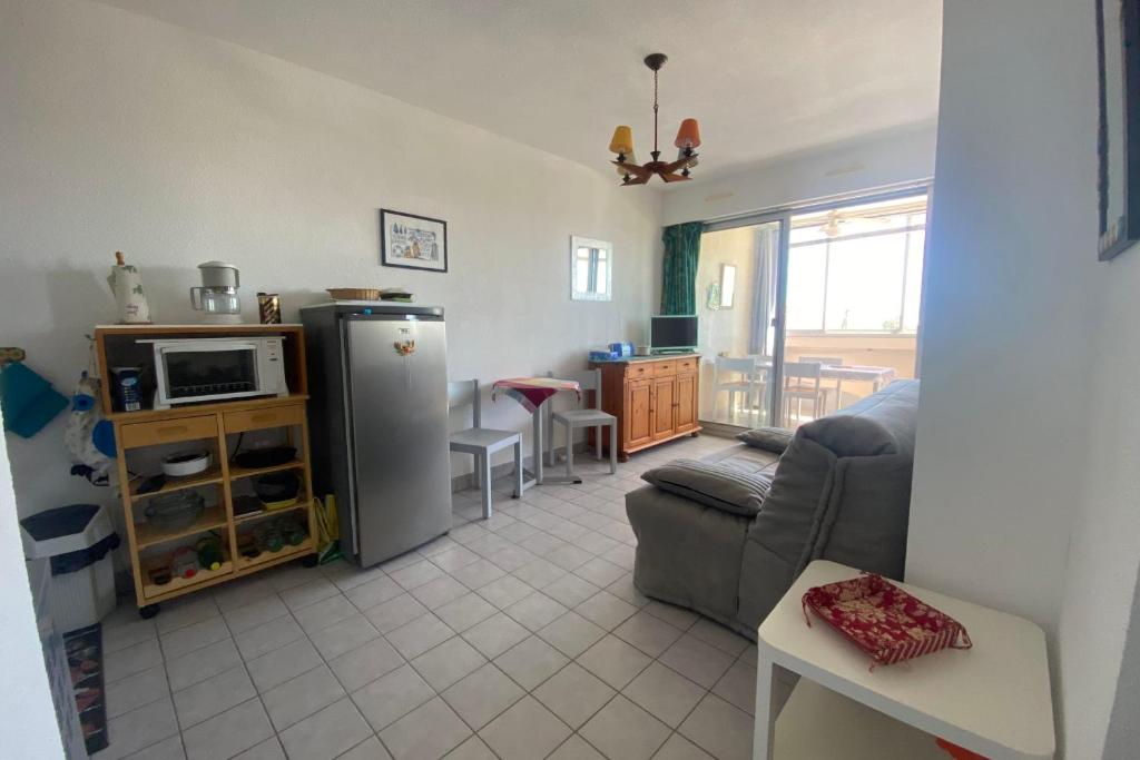 a living room with a couch and a refrigerator at Sea & Relaxation Stay in Frontignan