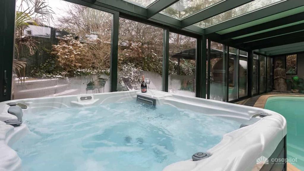 a jacuzzi tub in a room with windows at Ospa in Hamois