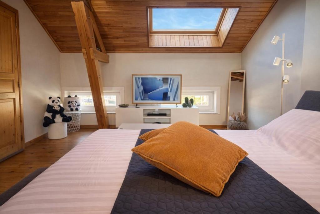 a bedroom with two beds and a flat screen tv at Loft Chaleureux - Le Chalet Montois in Mons