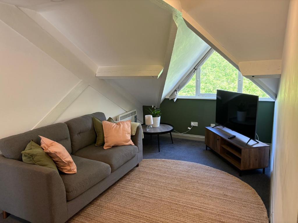 a living room with a couch and a flat screen tv at The Courtyard in Exeter
