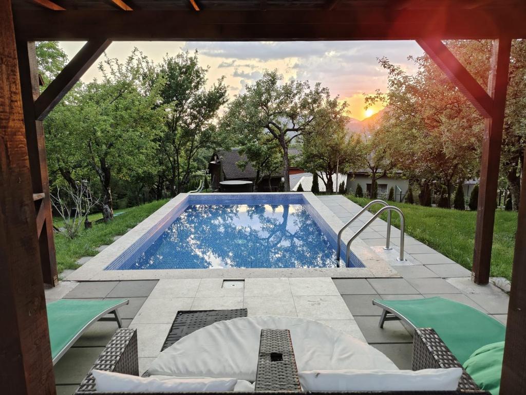 a swimming pool in a yard with chairs and a table at Pensiunea Verde in Baia-Sprie
