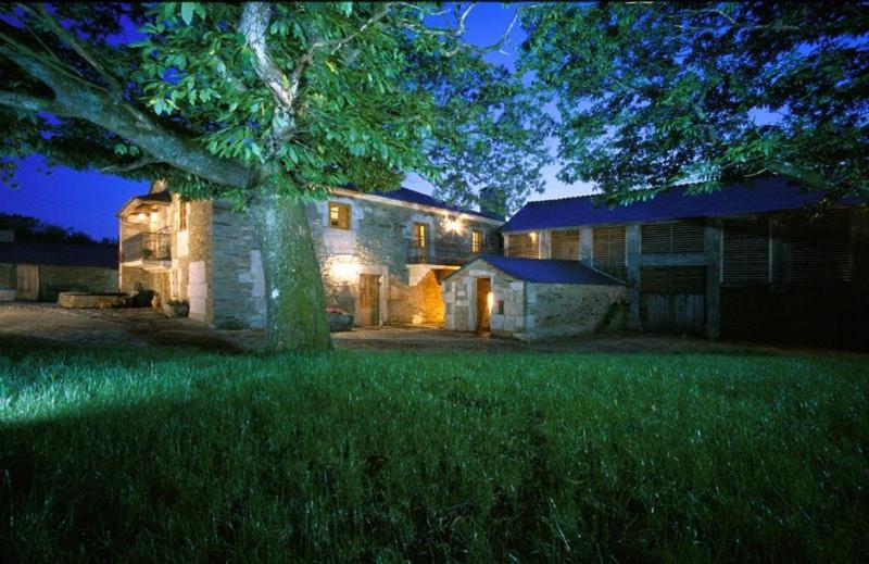 una casa grande con un árbol delante en Casa Lourán, en Monfero