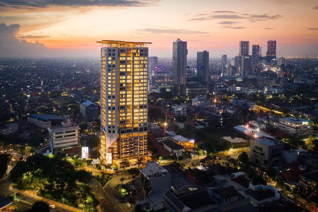 a city skyline with a tall building at night at Vasa Suite Surabaya in Surabaya