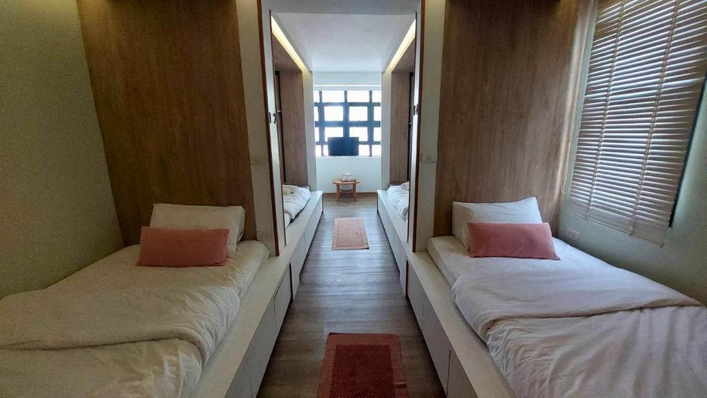 two beds in a room with two mirrors at Flow Garden Residence in Chiang Mai