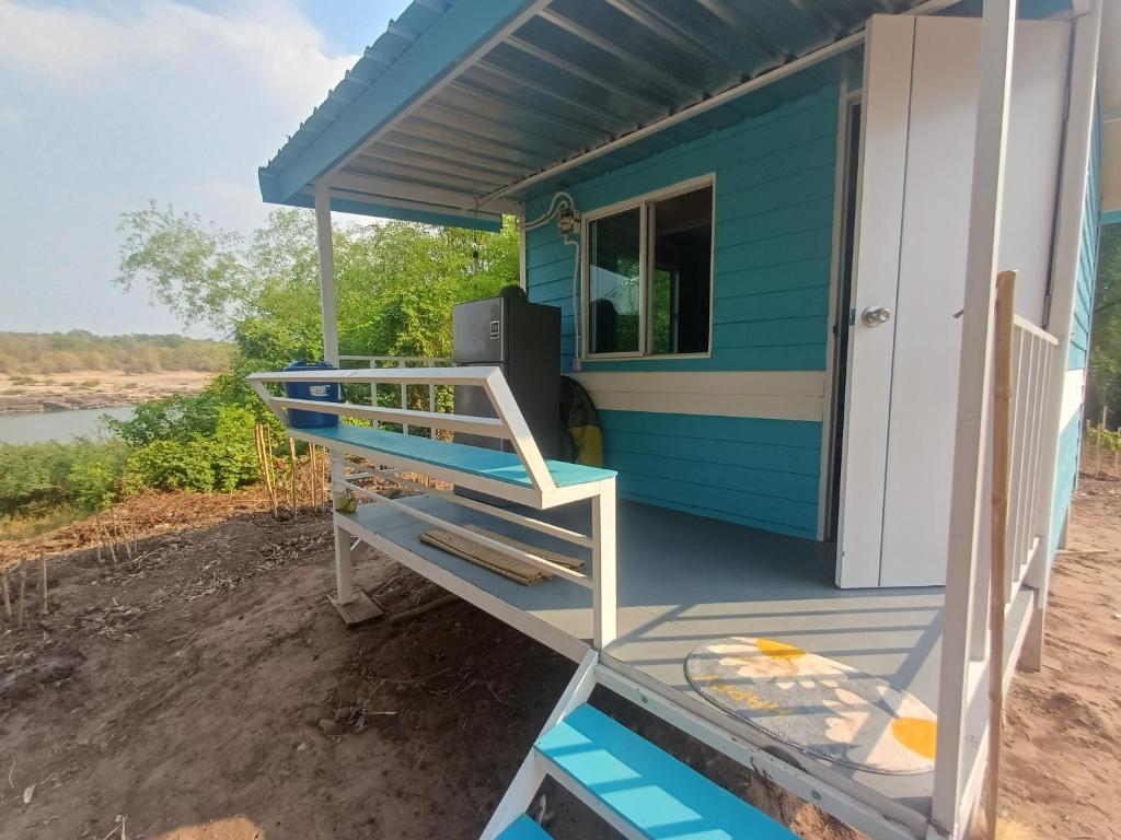 a blue and white house with a porch at S&A Camping in Ban Kum
