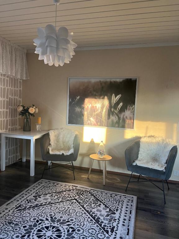 a living room with two chairs and a table at Spacious detached house in Mäntsälä