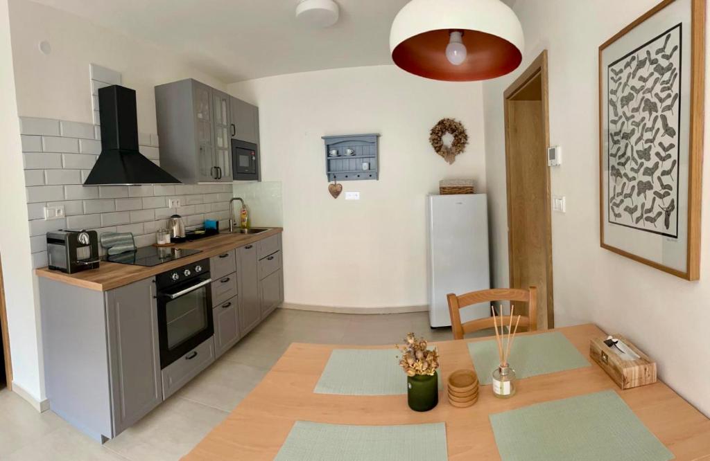 a kitchen with a table and a white refrigerator at Apartmán Blatka in Nová Pec