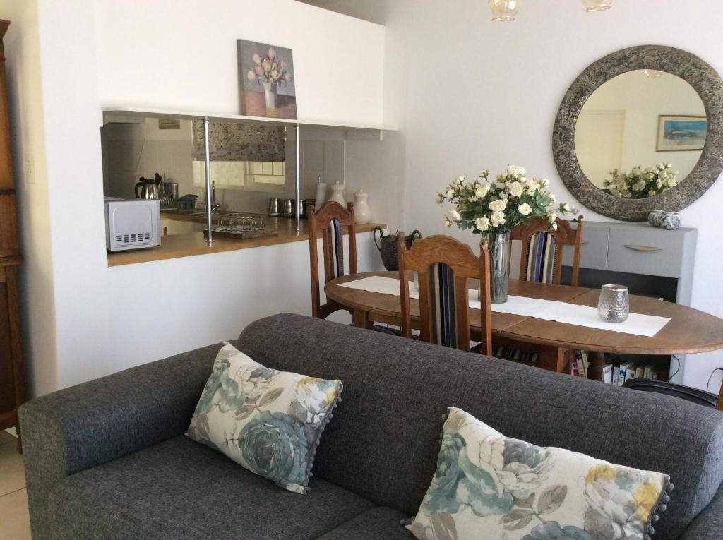 a living room with a couch and a dining room at On Broadwalk Cottage in Cape Town
