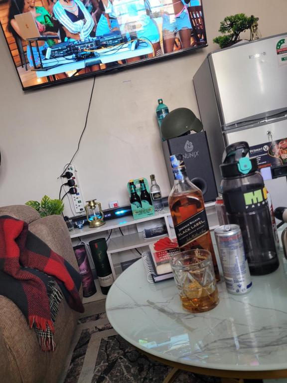 a table with a bottle of alcohol on top of it at Royal suburbs tsavo in Nairobi