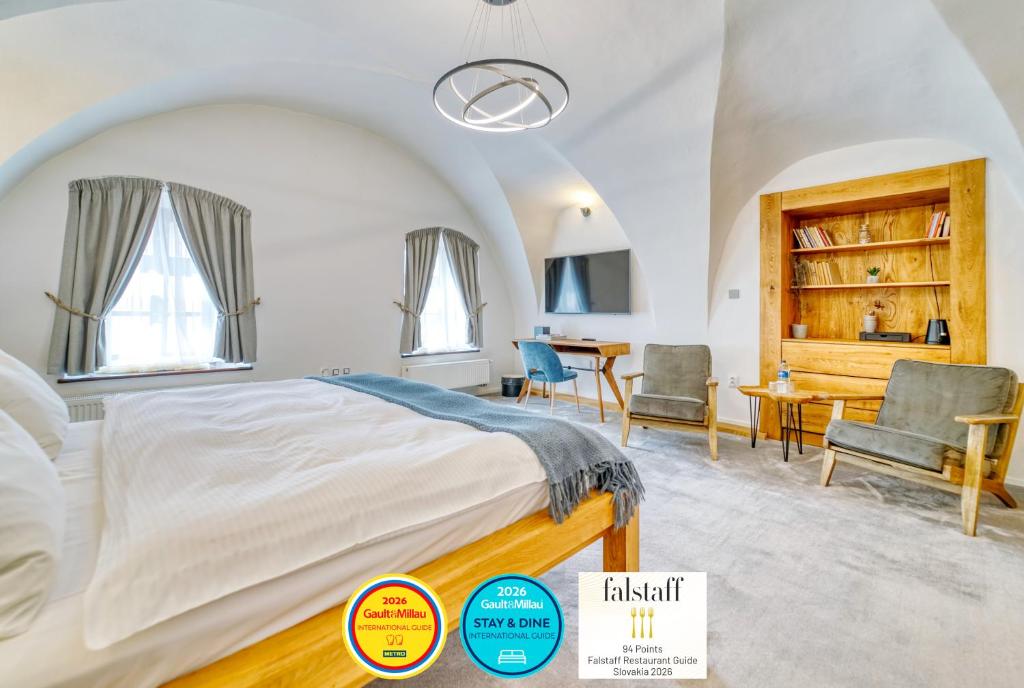 a bedroom with a bed and a table and chairs at DOMA u nás Boutique hotel & spa in Poprad