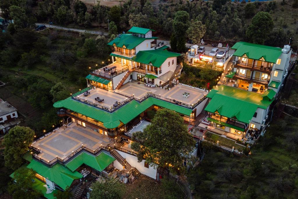 an aerial view of a large house with green roofs at Arkaya Mukteshwar by SuperGlitz Resorts Pvt Ltd in Mukteshwar